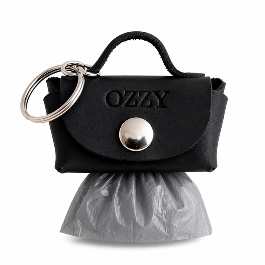 Black handbag-shaped keychain with 'Ozzy' branding and a plastic bag on a white background