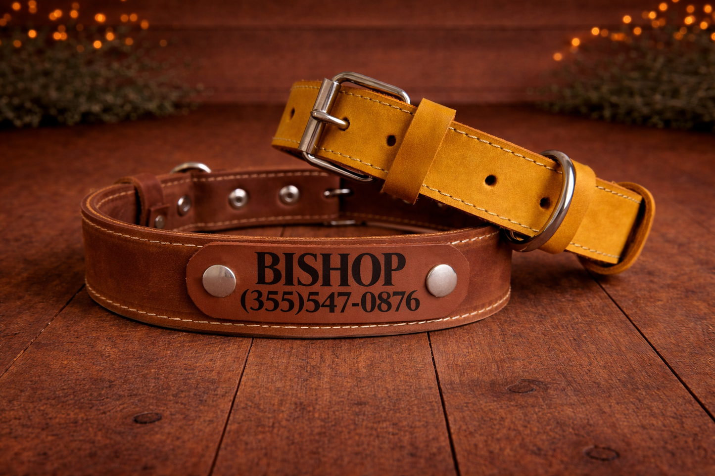 Brown leather dog collar with engraved name and phone number on a wooden surface.