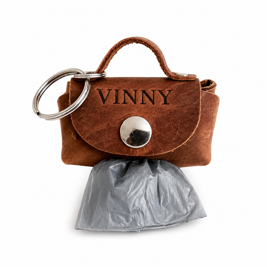Brown leather keychain with 'VINNY' branding and a gray bag attached on a white background