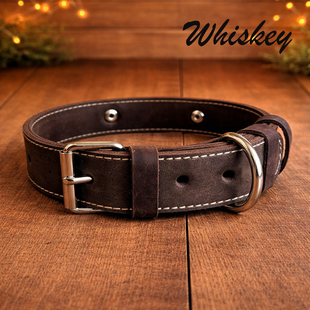 Brown leather dog collar with silver buckle on a wooden surface, branded 'Whiskey'.