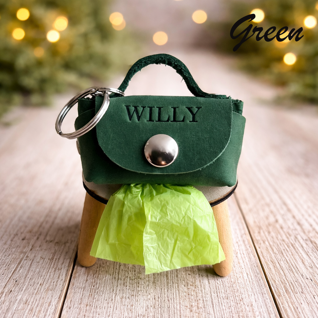 Green handbag-shaped keychain with 'WILLY' branding on a wooden surface.