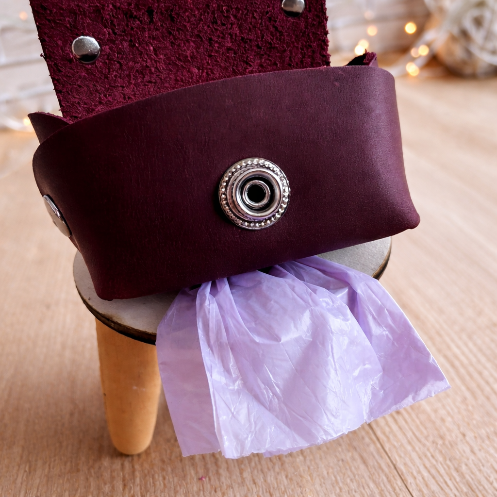 Purple clutch bag with decorative button and tissue paper on a wooden surface