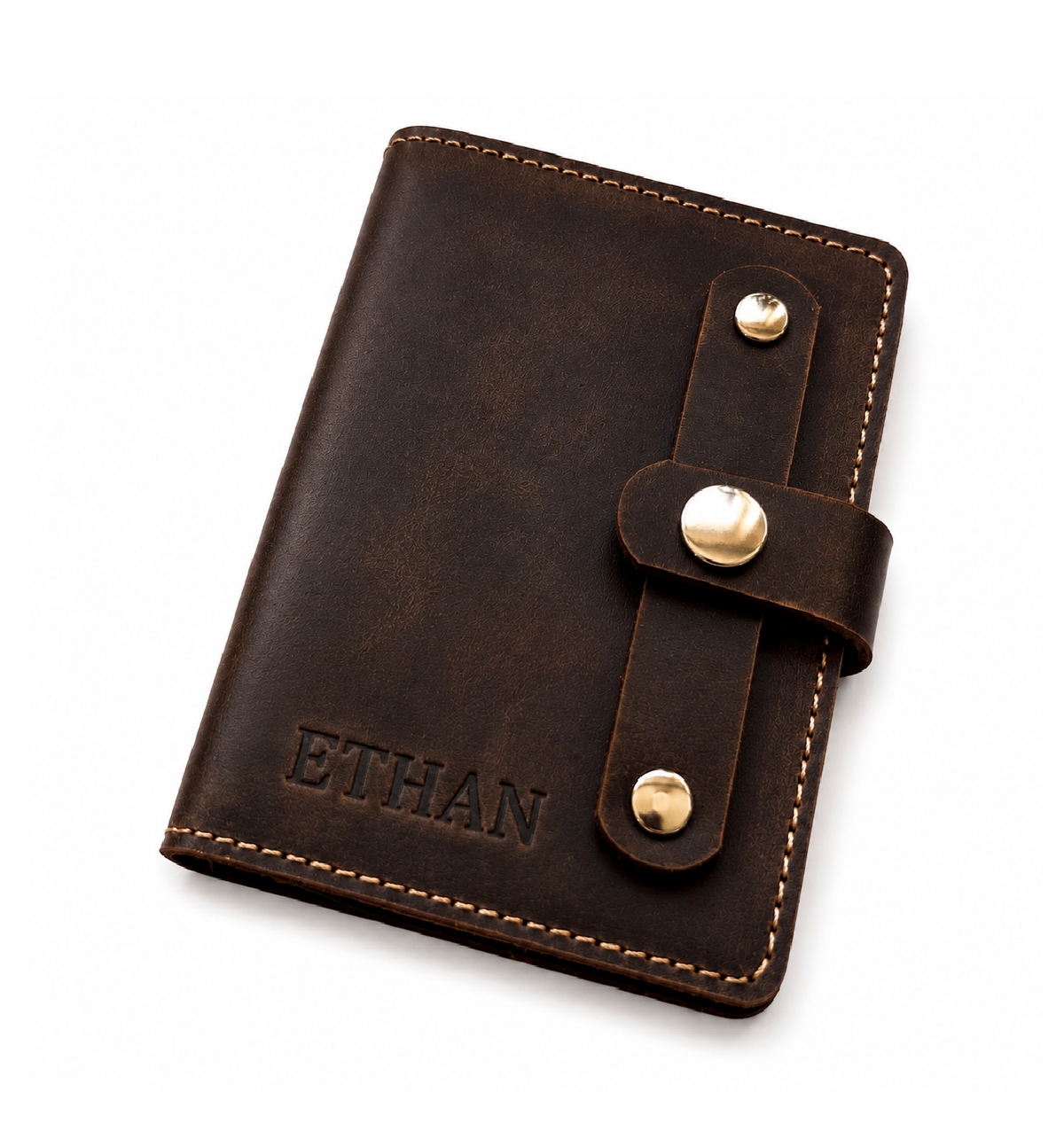 A dark brown leather journal cover with a snap strap closure and gold-tone metal snaps, featuring the name 'ETHAN' embossed on the front, shown on a clean white background.