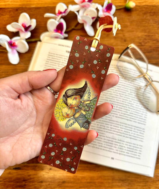 Leather bookmark with floral print placed on an open book, showcasing its elegant design and functionality