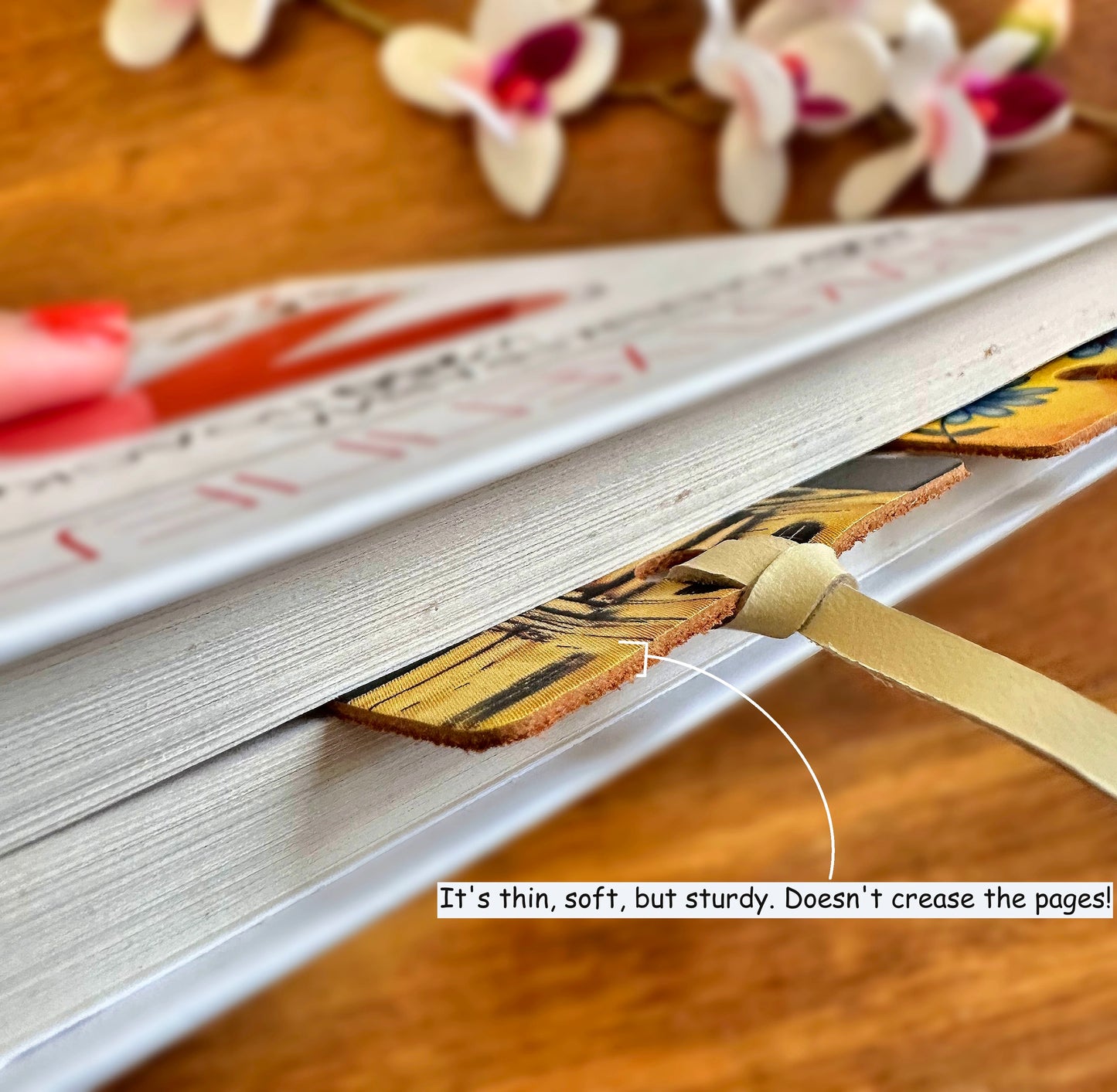 Leather bookmark with floral design resting on a wooden surface, showcasing its natural beauty and intricate details