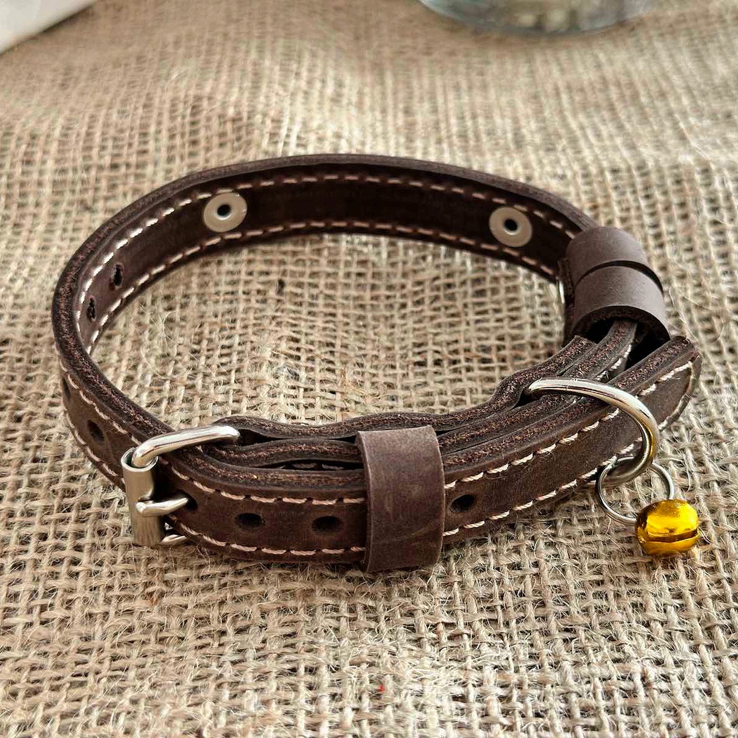 Custom leather cat collar for pets, personalized with name and phone number.