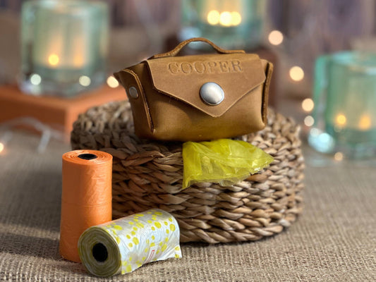 Leather poop bag holder in front view, showing sleek design and compact size